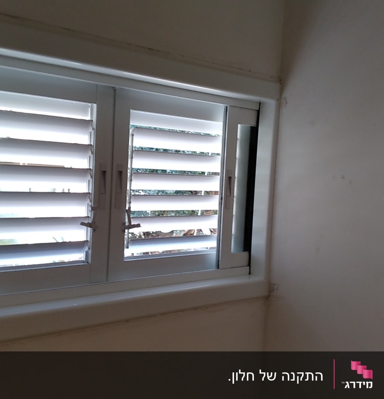 תריסי אלומיניום לבנים בחלון פנימי